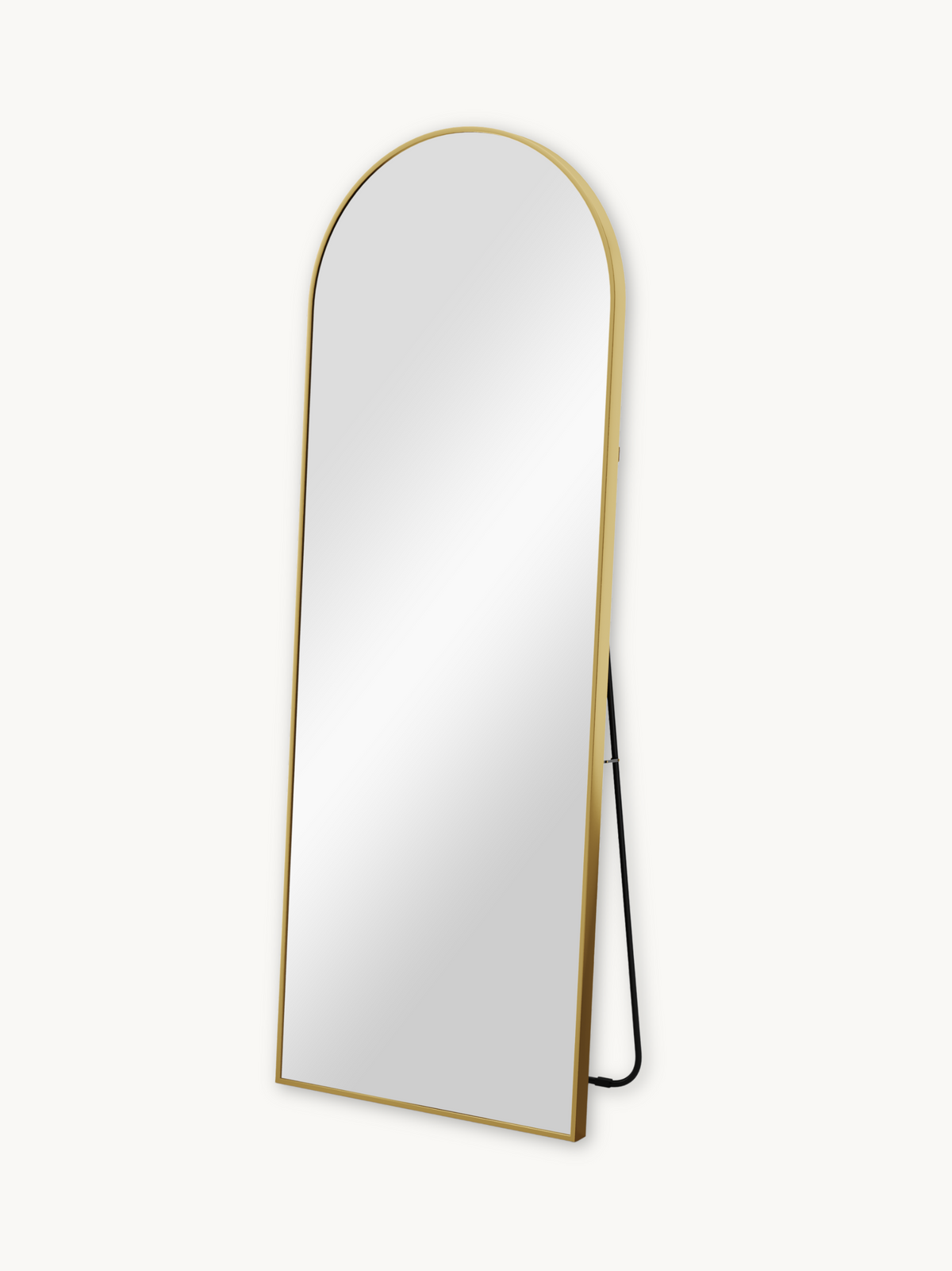 Angled three-quarter view of full-length arched mirror with slim gold aluminium frame and black metal easel stand, white b…