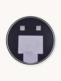 Back of round LED bathroom mirror showing dark panel, white electronic housing with power cable, and two wall-mounting bra…