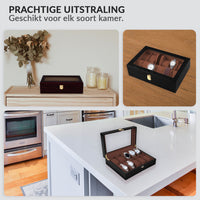 Black wood watch box shown in three lifestyle settings: on a shelf, open on a wooden surface with watches, and open on a k…