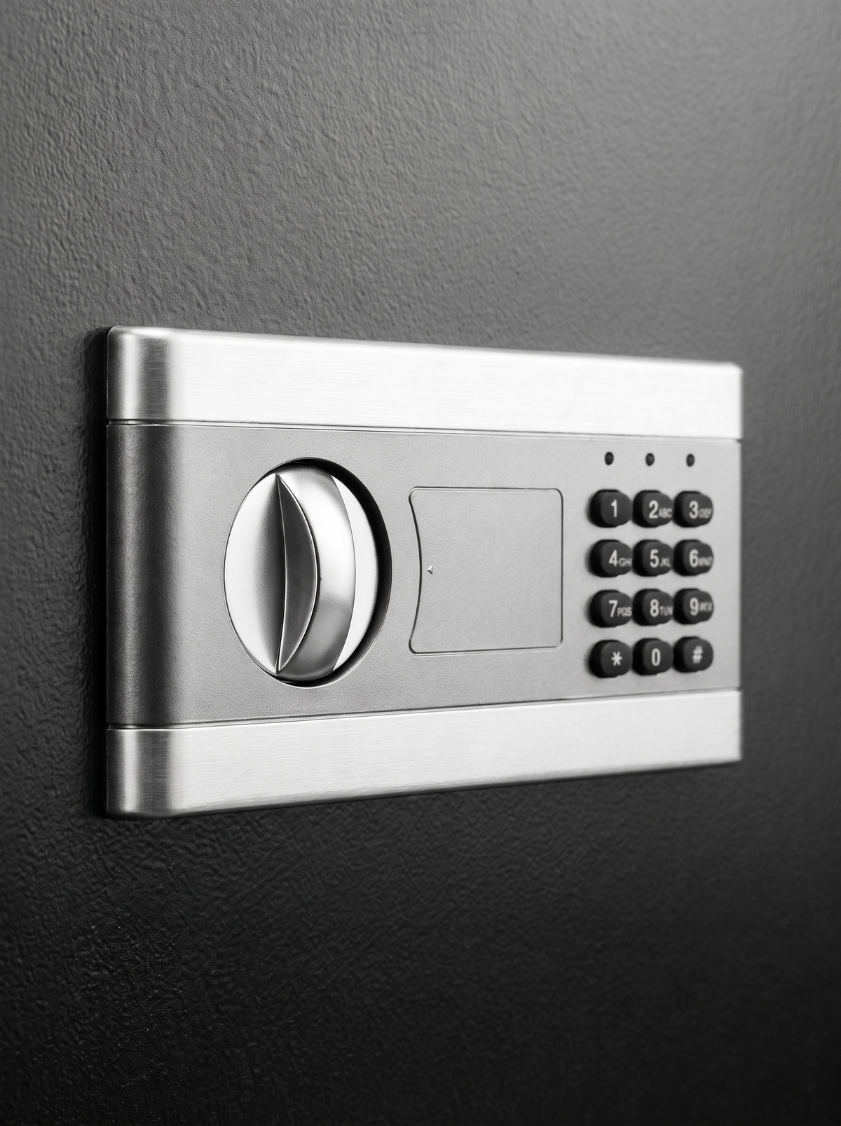 Close-up of silver brushed-steel digital lock panel with rotary dial and numeric keypad on black safe door