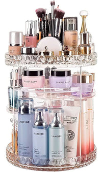Clear 3-tier rotating makeup organiser filled with skincare bottles, makeup brushes, creams and perfumes on white background