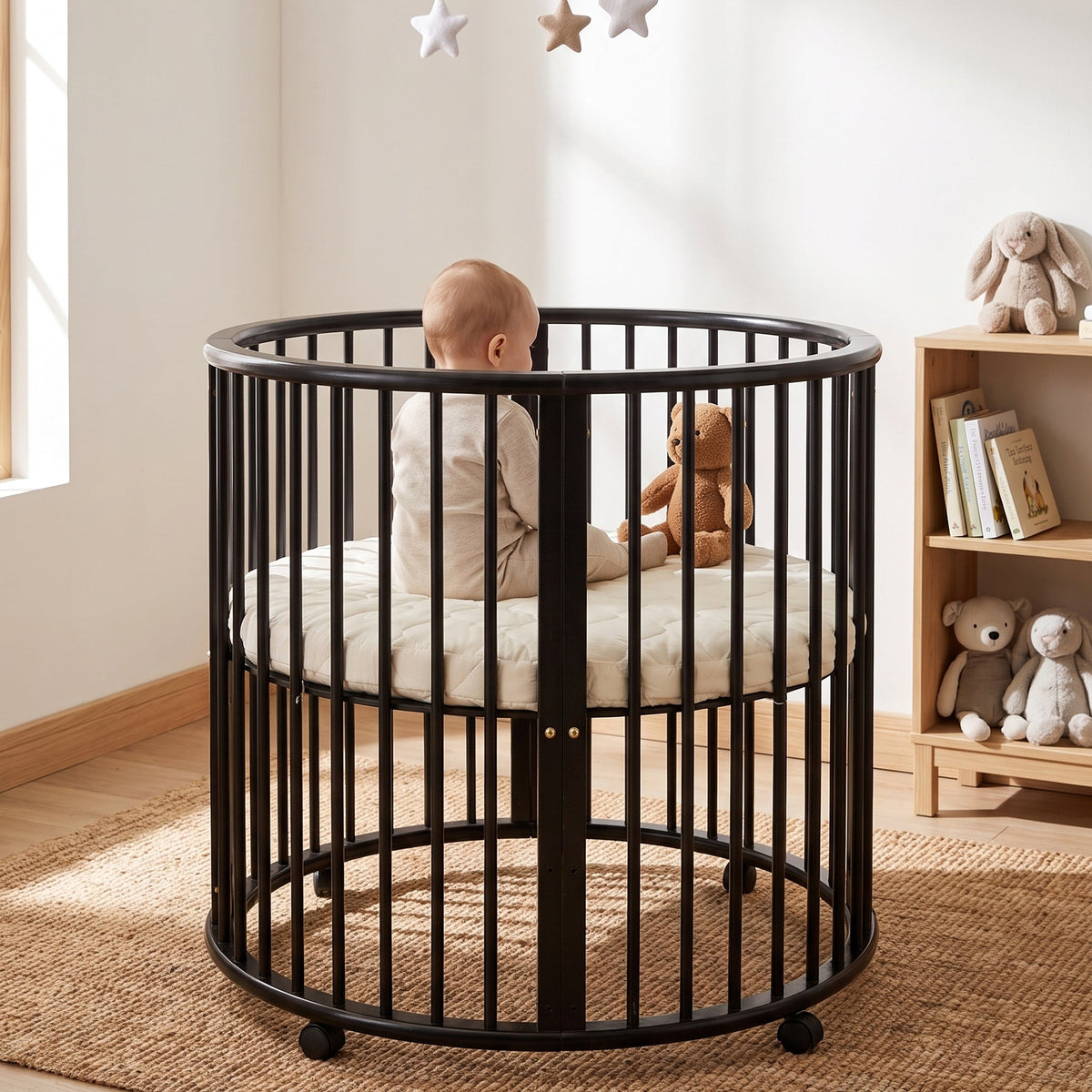 Black round wooden playpen with baby and teddy bear inside, styled in a sunlit nursery with jute rug and toy shelf nearby