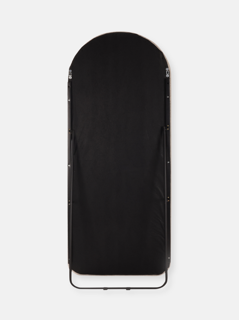 Back view of arched floor mirror showing black fabric backing, silver toggle clips along frame edges, and curved black met…